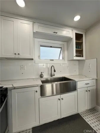 a kitchen with white cabinets and white appliances