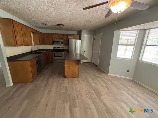 a kitchen with granite countertop wooden floors and wide window
