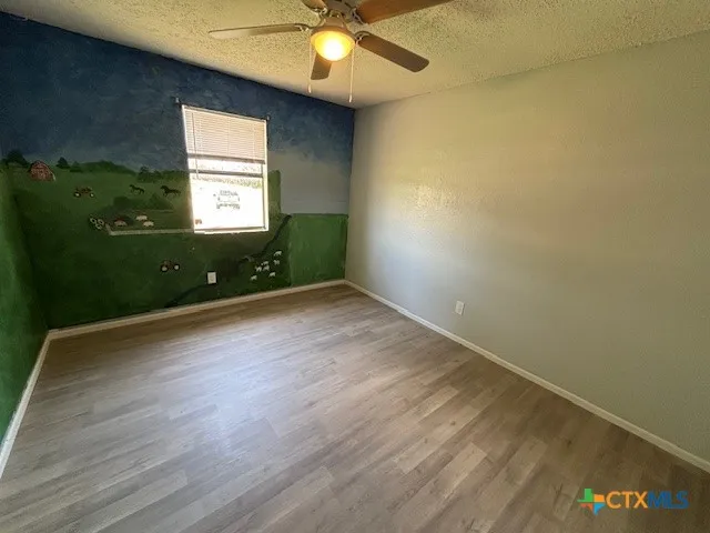 an empty room with window and fan