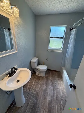 a bathroom with a sink toilet and a mirror
