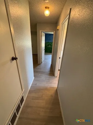 a view of a hallway with wooden floor and staircase