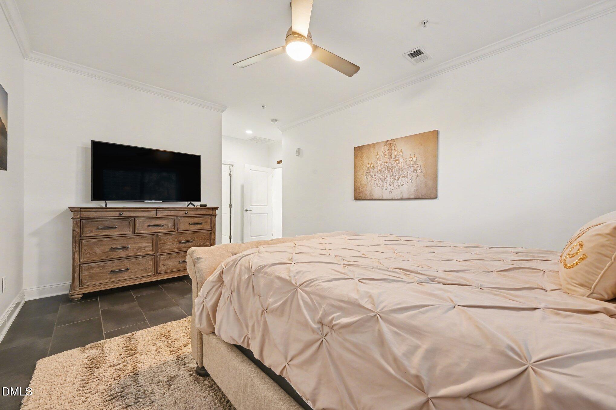 10420 Sablewood Drive, Unit 112 Raleigh, NC 27617 - Photo 15 of 31 a bedroom with a bed and a flat screen tv