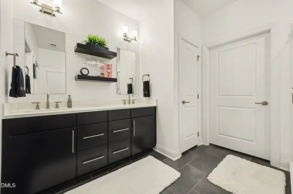a spacious bathroom with double vanity and a mirror