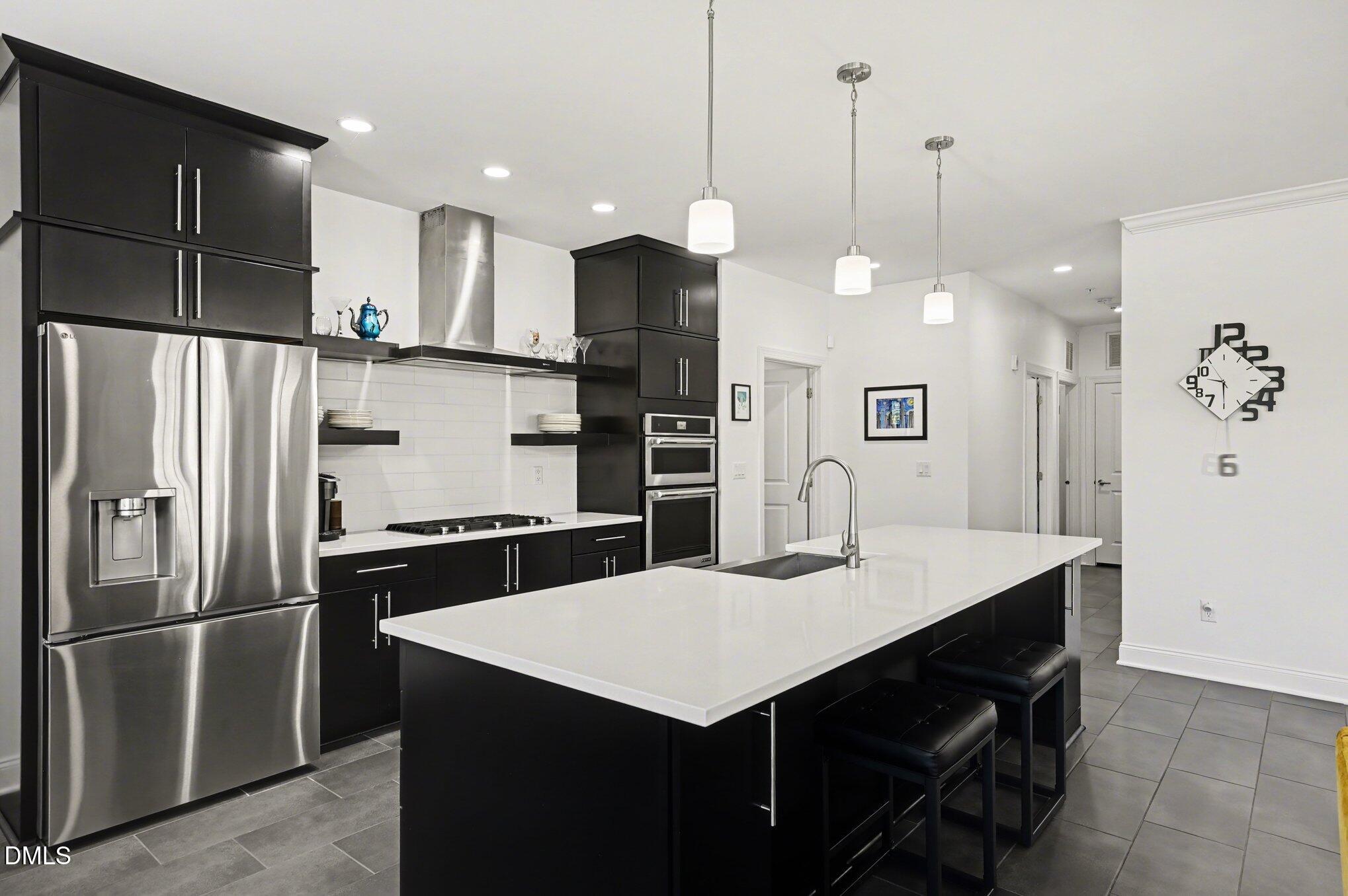 10420 Sablewood Drive, Unit 112 Raleigh, NC 27617 - Photo 7 of 31 a kitchen with a refrigerator a sink and kitchen island