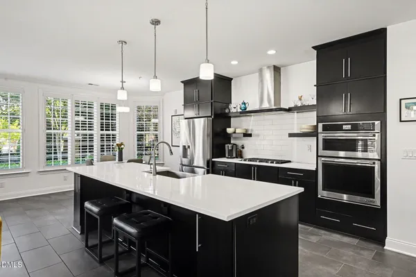 a kitchen with a sink a kitchen island stainless steel appliances and cabinets