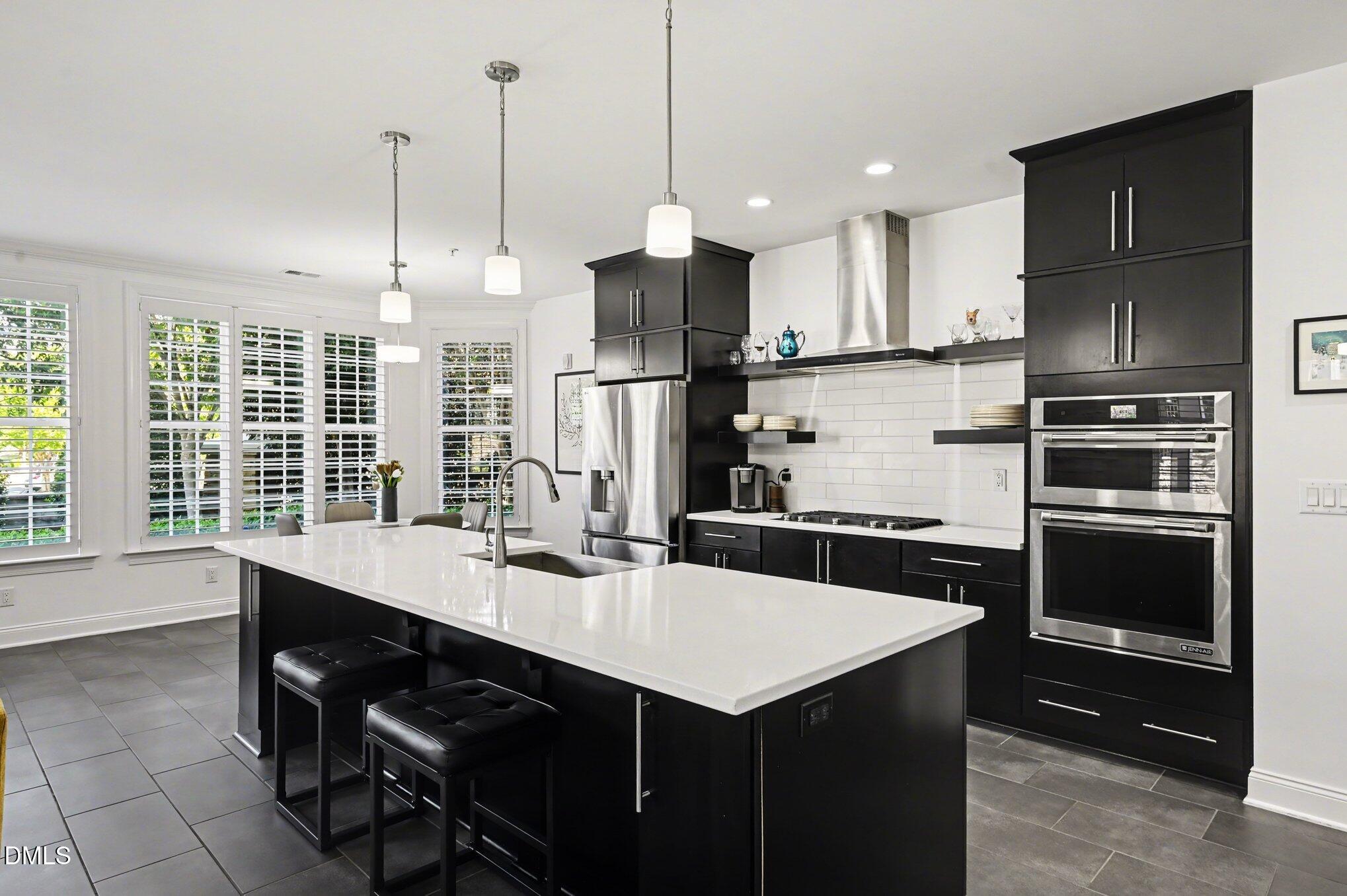 10420 Sablewood Drive, Unit 112 Raleigh, NC 27617 - Photo 9 of 31 a kitchen with a sink a kitchen island stainless steel appliances and cabinets