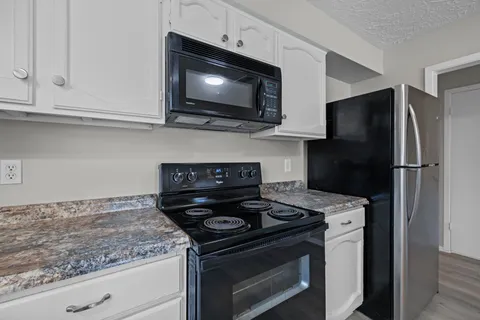 a kitchen with stainless steel appliances granite countertop a stove microwave and refrigerator