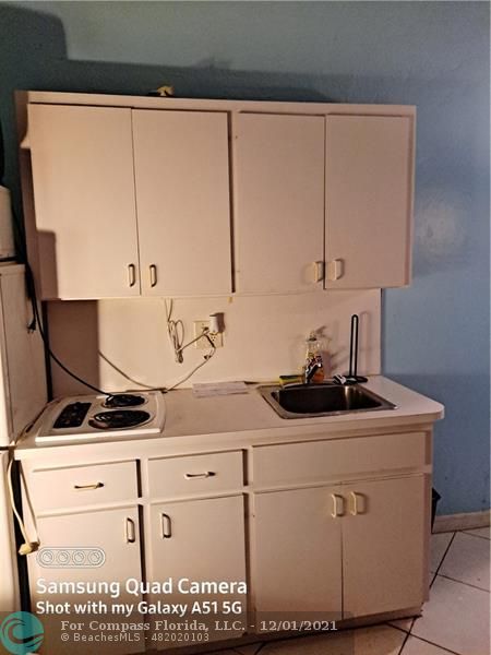 255 West 24th Street, Unit 105 Miami Beach, FL 33140 - Photo 25 of 47 a kitchen with white cabinets sink and white appliances