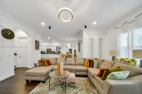 a living room with furniture flowers and a chandelier