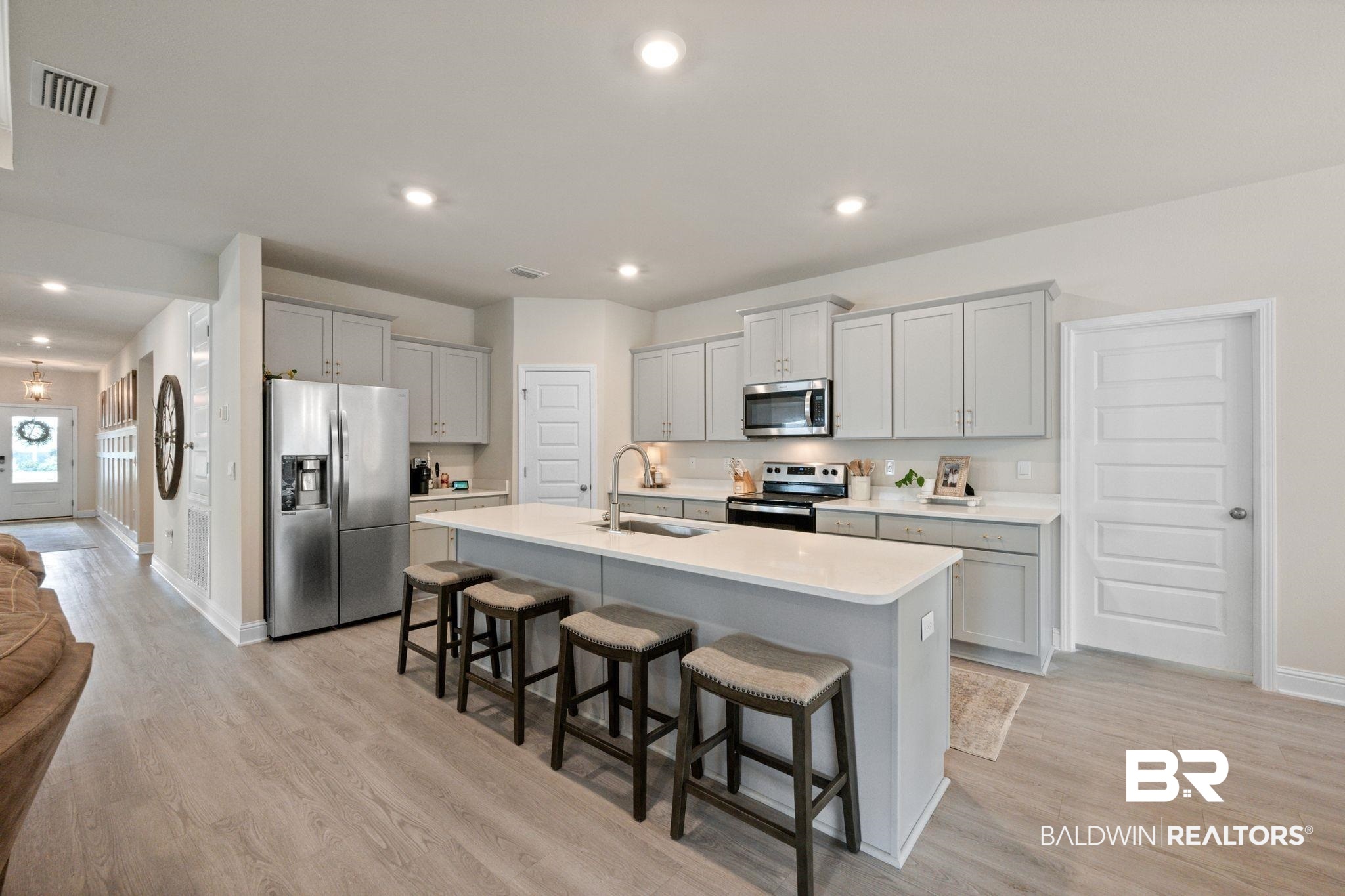681 Calibre Street Fairhope, AL 36532 - Photo 22 of 56 Kitchen featuring a kitchen island with sink, sink, appliances with stainless steel finishes, and light hardwood / wood-style floors
