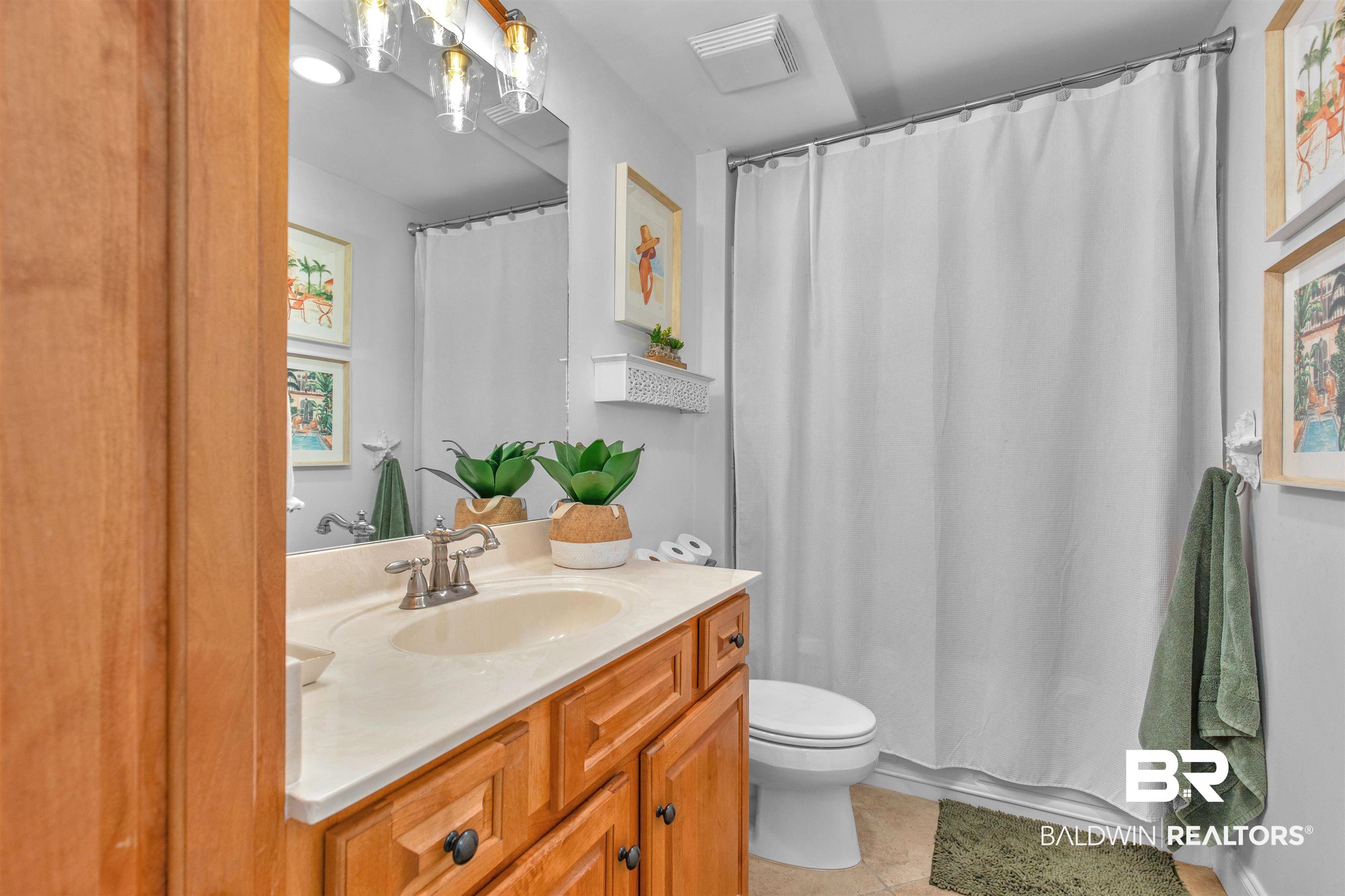 25909 Canal Road, Unit 301 Orange Beach, AL 36561 - Photo 19 of 43 Bathroom with a shower with curtain, vanity, toilet, and tile patterned flooring