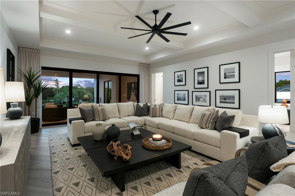 6704 Newport Road Naples, FL 34109 - Photo 30 of 47 a living room with furniture ceiling fan and a large window