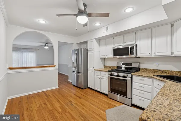 a kitchen with stainless steel appliances granite countertop a refrigerator stove microwave and sink