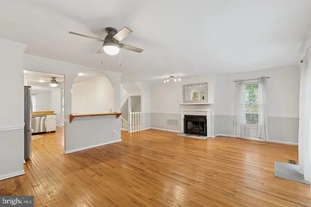 a view of a livingroom with a fireplace a chandelier and wooden floor