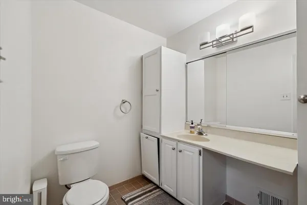 a bathroom with a granite countertop sink a toilet a mirror and shower
