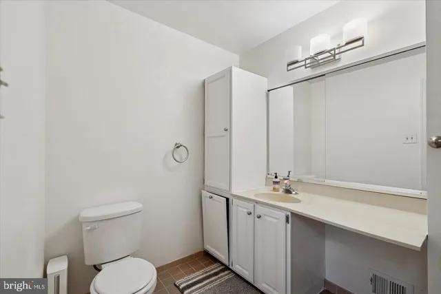 a bathroom with a granite countertop sink a toilet a mirror and shower