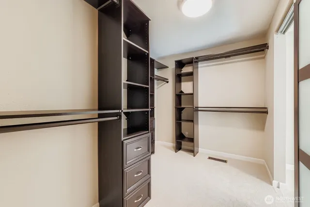 a view of walk in closet with empty racks