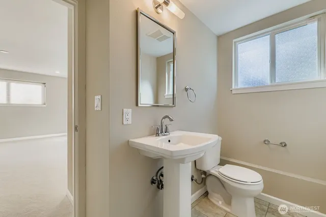 a bathroom with a sink toilet and mirror