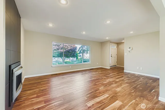 an empty room with wooden floor and a window