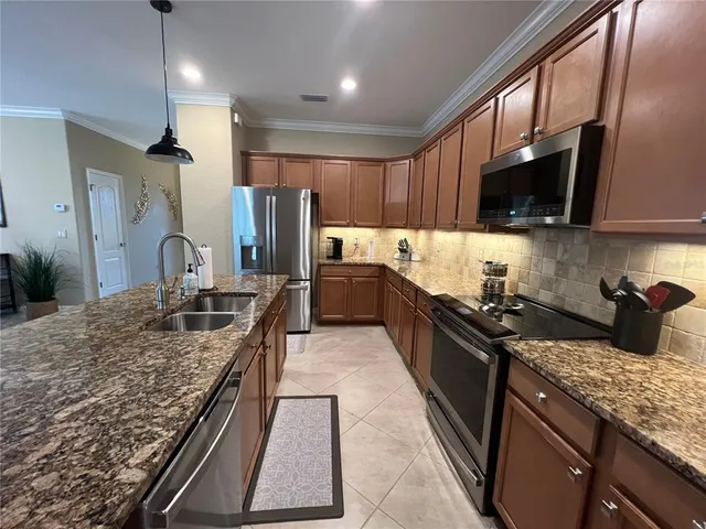 a kitchen with stainless steel appliances granite countertop a sink stove and refrigerator