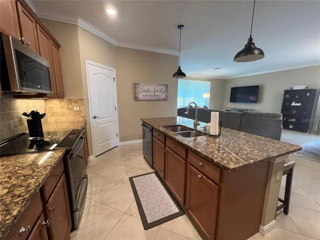 a kitchen with granite countertop stainless steel appliances and wooden cabinets