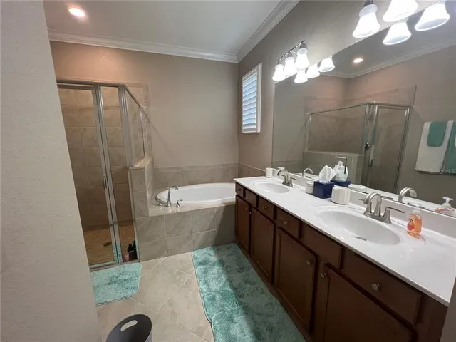a white bath tub sitting next to a white sink and vanity
