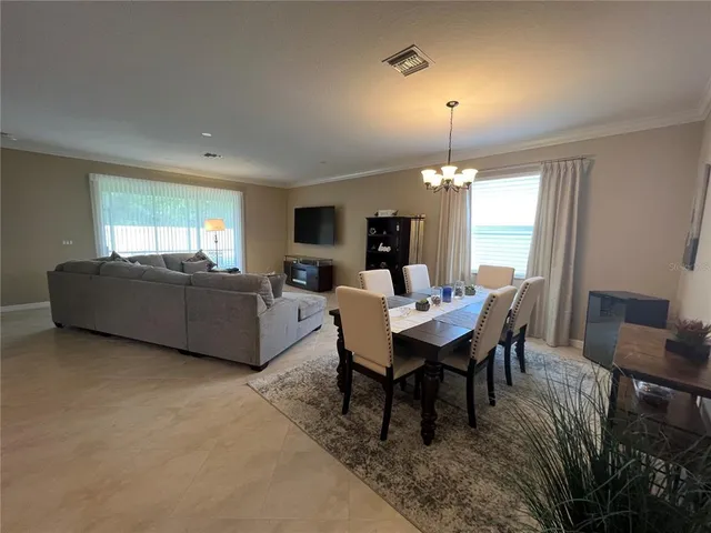 a dining room with furniture a chandelier and window