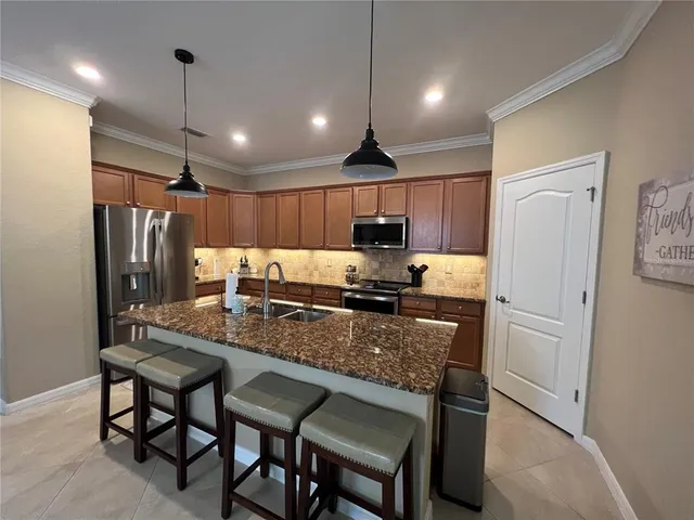 a large kitchen with granite countertop a stove top oven a sink a counter space and cabinets