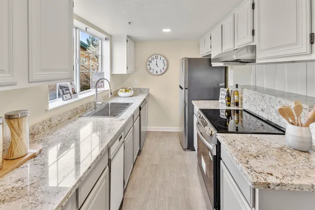 a kitchen with stainless steel appliances granite countertop a sink stove and refrigerator