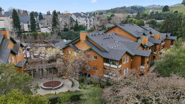 an aerial view of residential house with outdoor space and trees around