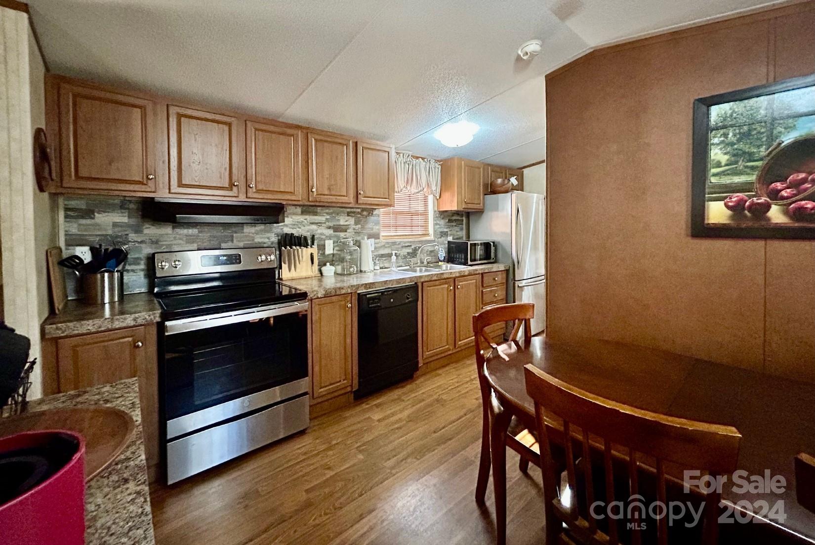 7486 Buff Allen Road Hickory, NC 28602 - Photo 4 of 13 a kitchen with stainless steel appliances granite countertop a stove a sink dishwasher and a microwave oven with cabinets