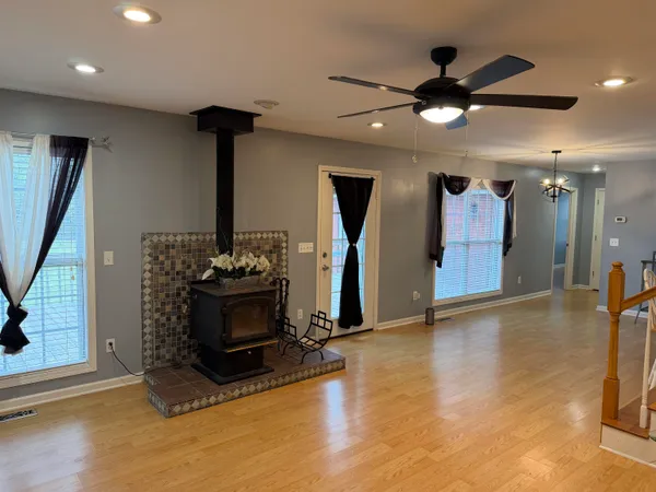 a living room with hard wood floors and a ceiling fan