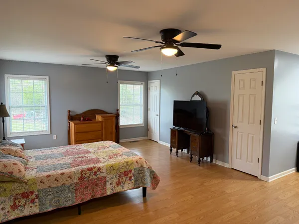 a bedroom with a bed and a television on the dresser