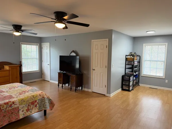 a bedroom with a bed and wooden floor