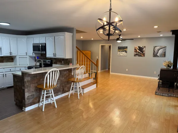 a kitchen with stainless steel appliances granite countertop a stove a sink a microwave and a refrigerator