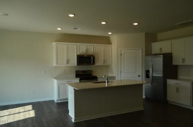 a kitchen with kitchen island white cabinets and stainless steel appliances