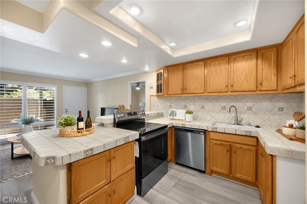 3020 Associated Road, Unit 110 Fullerton, CA 92835 - Photo 3 of 34 a kitchen with a sink stove and cabinets