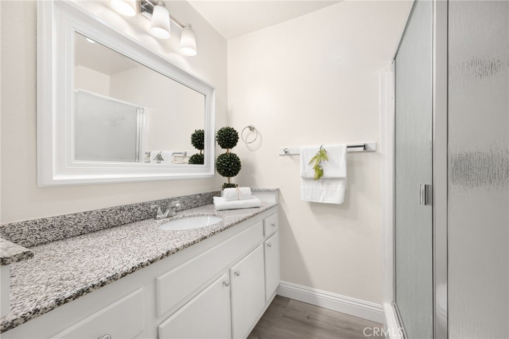 3020 Associated Road, Unit 110 Fullerton, CA 92835 - Photo 10 of 34 a bathroom with a granite countertop sink and a mirror