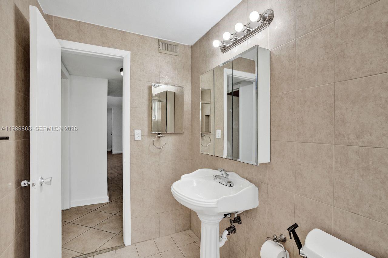 9454 Southwest 77th Avenue, Unit S1 Miami, FL 33156 - Photo 16 of 20 a bathroom with a sink mirror and toilet