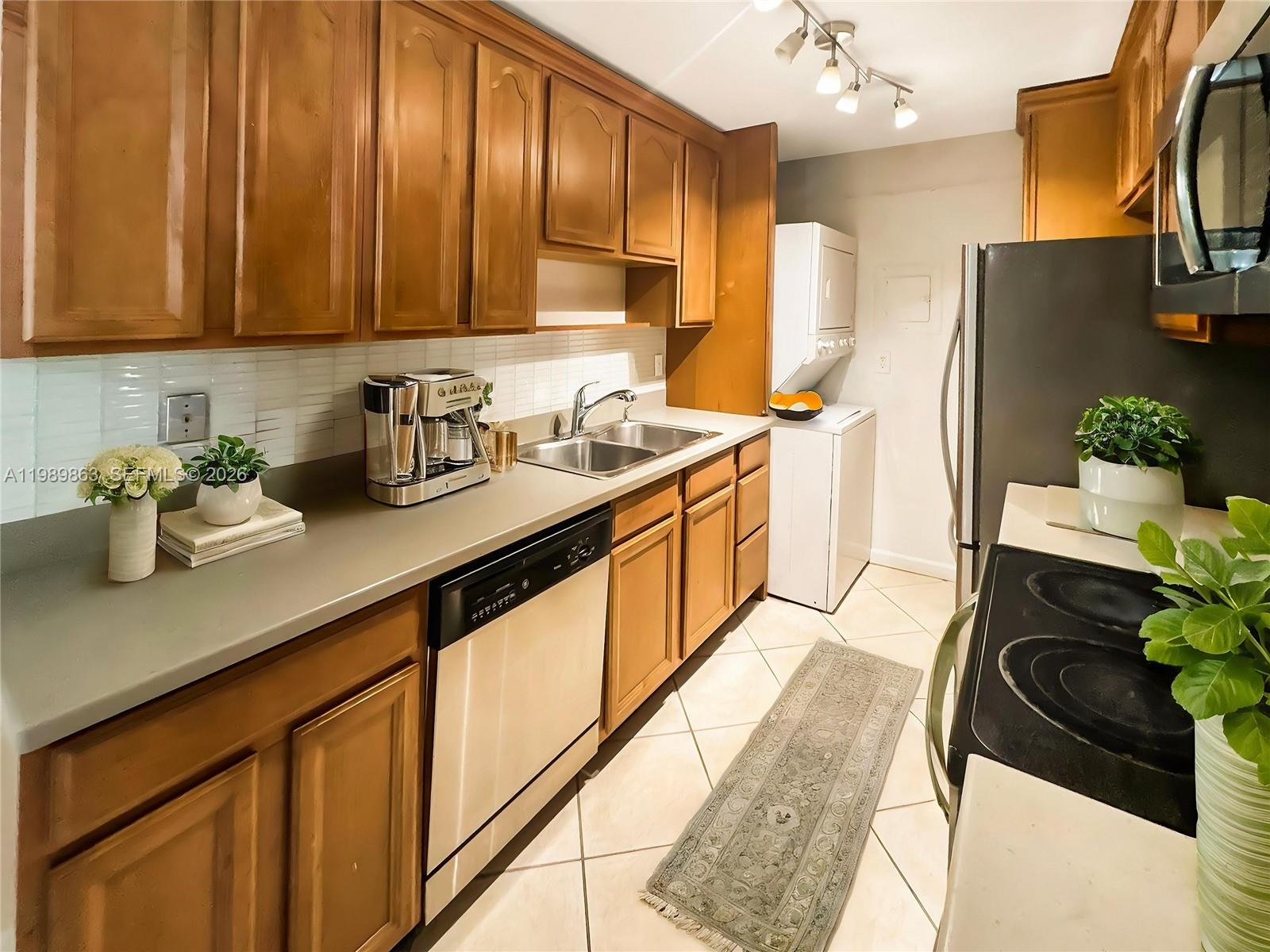 9454 Southwest 77th Avenue, Unit S1 Miami, FL 33156 - Photo 3 of 20 a kitchen with stainless steel appliances granite countertop a sink stove and refrigerator