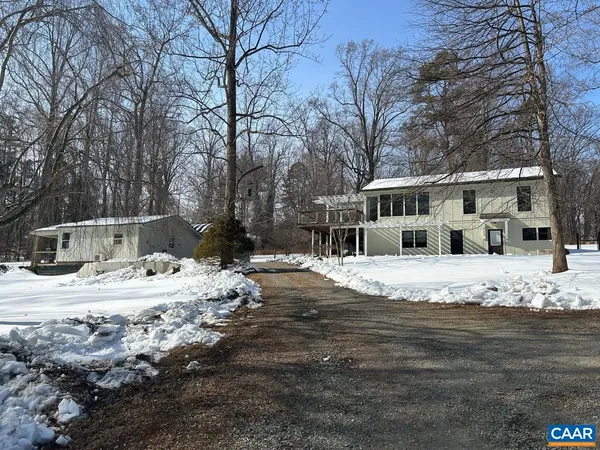 a view of a house with snow on the side of the road
