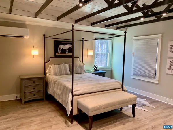 a bedroom with a bed window and a table