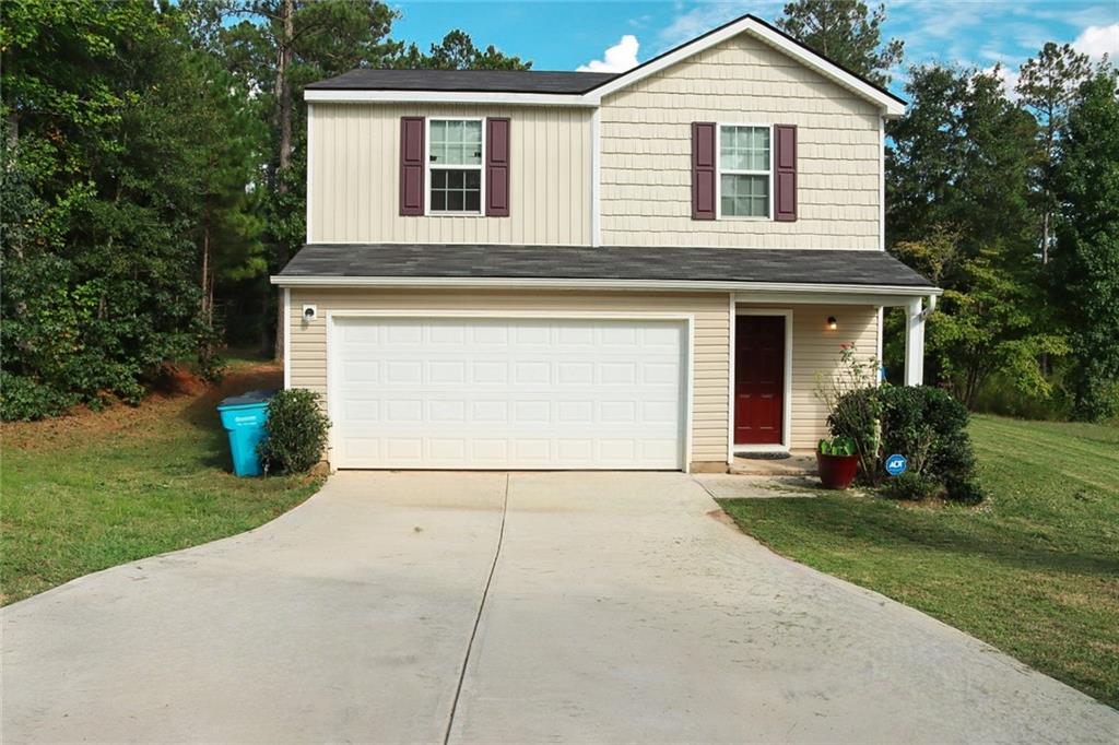 a front view of a house with a yard and garage