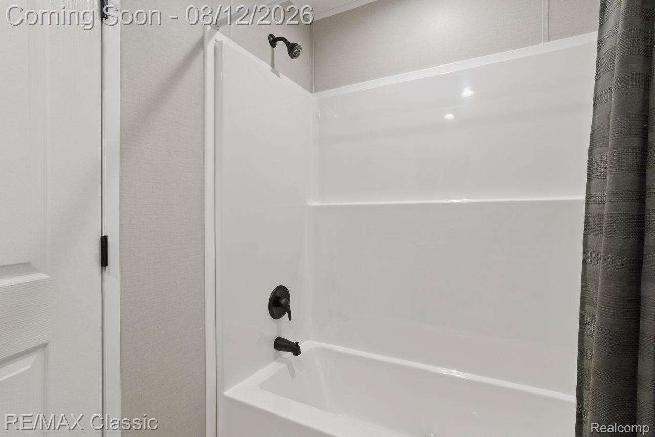 7105 West Vienna Road Clio, MI 48420 - Photo 16 of 23 Bathtub and shower combination with matte black fixtures