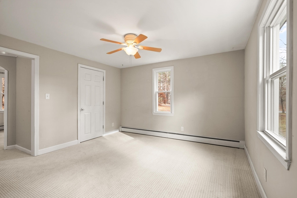 319 Pleasant Street Dunstable, MA 01827 - Photo 13 of 36 an empty room with windows and chandelier fan