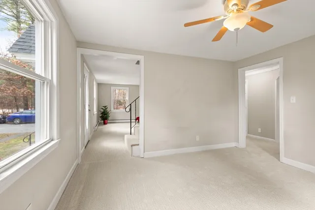 a view of a room with a chandelier fan and windows