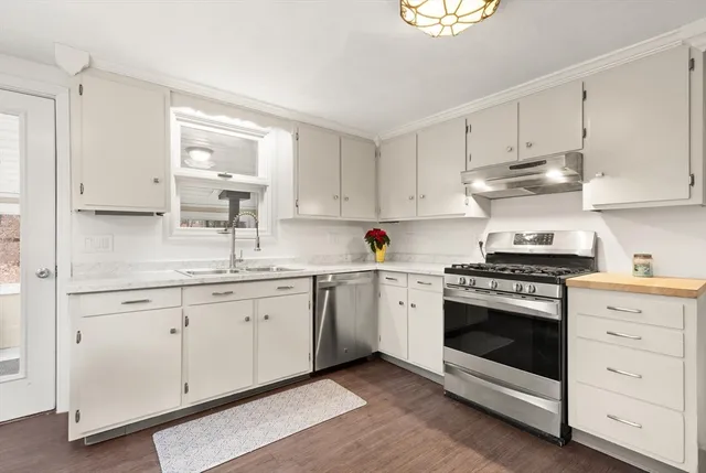 a kitchen with granite countertop white cabinets and white appliances