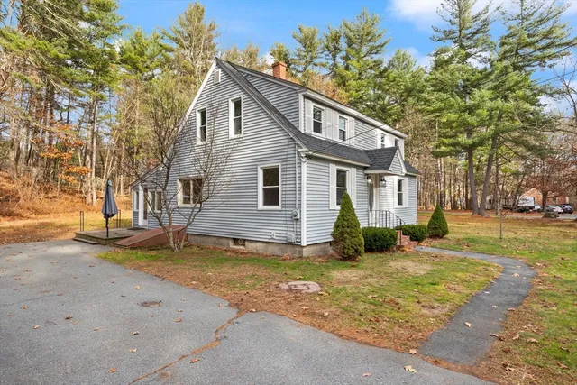 a view of a house with a yard and large tree