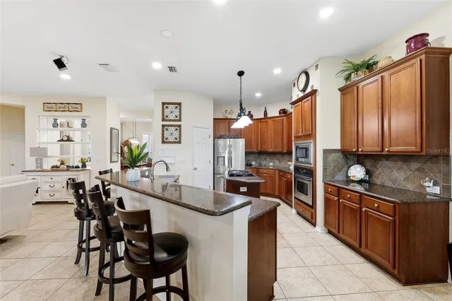 a kitchen with stainless steel appliances kitchen island granite countertop a sink and cabinets