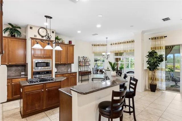 a kitchen with granite countertop a table chairs stove and cabinets